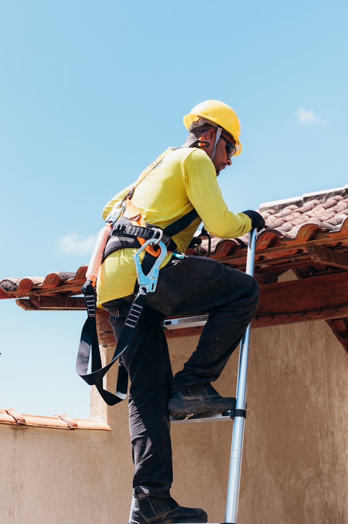 Professional construction worker safely ascending ladder on-site.